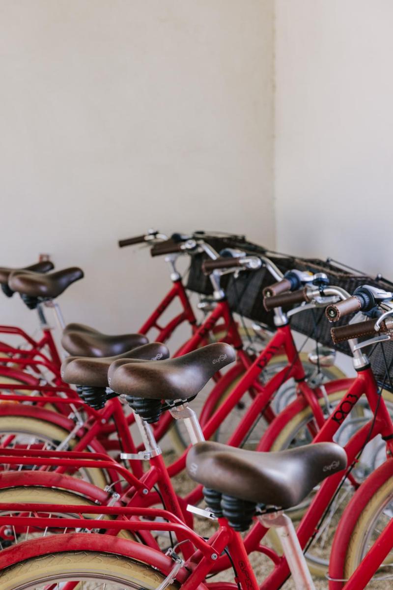 une rangée de vélos rouges garés côte à côte dans l'établissement Oustau Camarguen Hôtel & Spa, au Grau-du-Roi