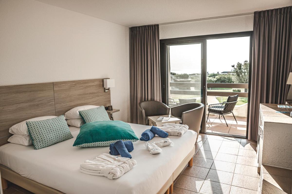 une chambre d'hôtel avec un lit avec des serviettes dessus dans l'établissement Thalacap Camargue, à Saintes-Maries-de-la-Mer