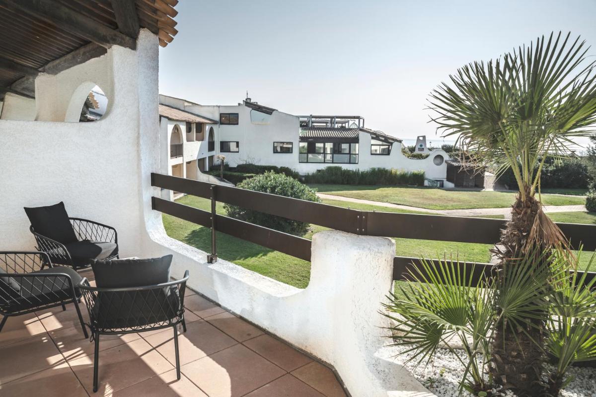 d'un balcon avec des chaises et une cour. dans l'établissement Thalacap Camargue, à Saintes-Maries-de-la-Mer