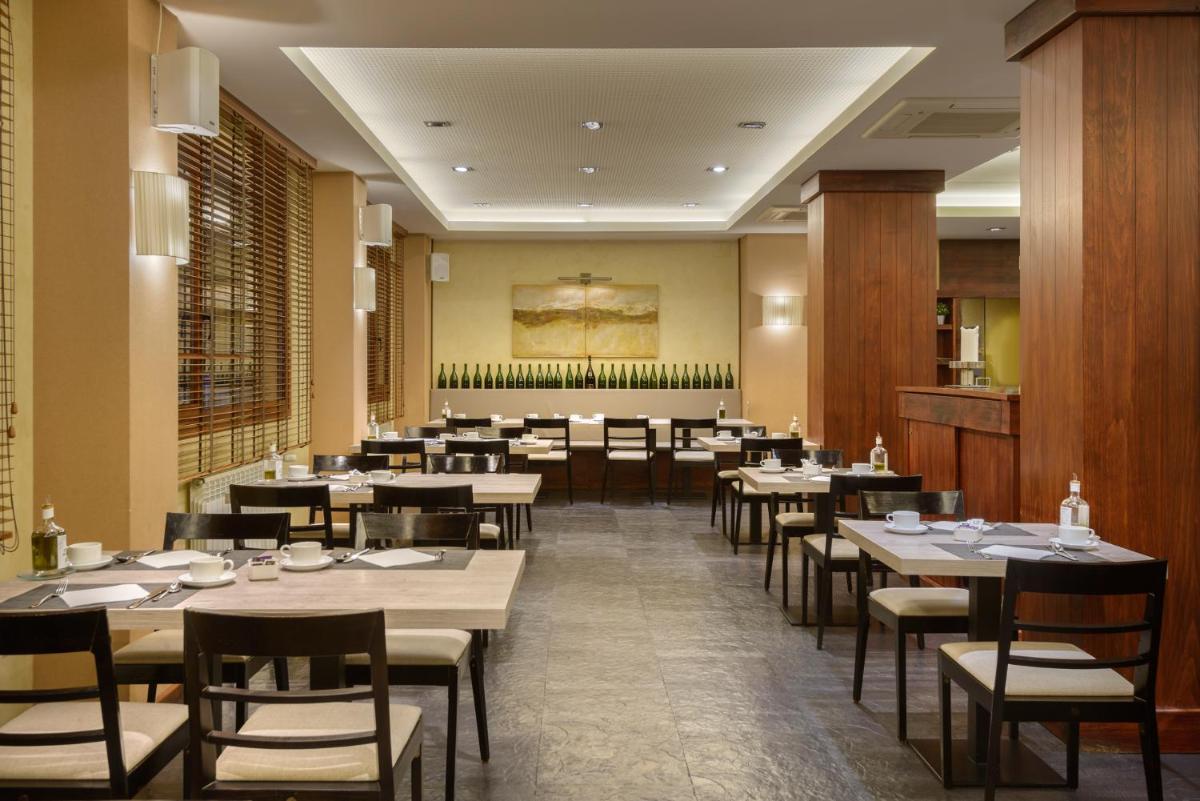 Un comedor con mesas y sillas y un restaurante. en Hotel Saliecho, en Formigal