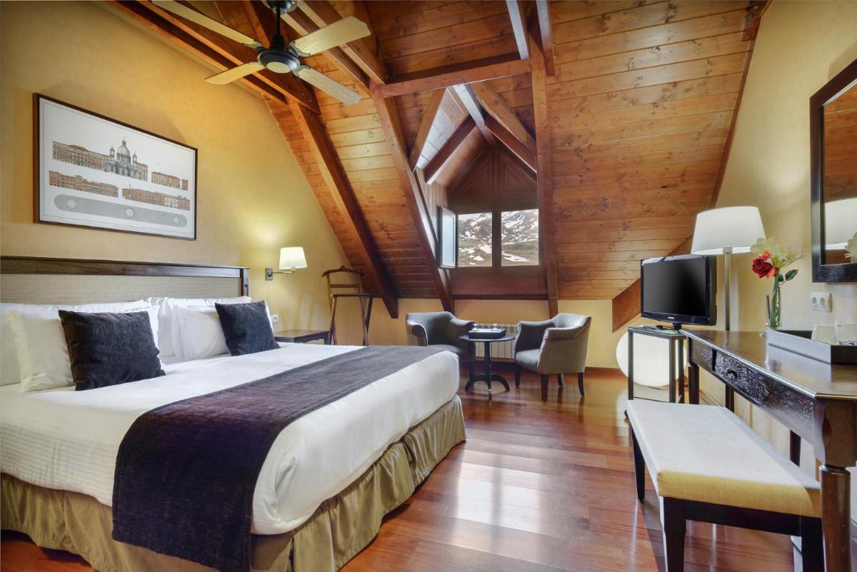Una habitación de hotel con una cama grande y un televisor. en Hotel Saliecho, en Formigal