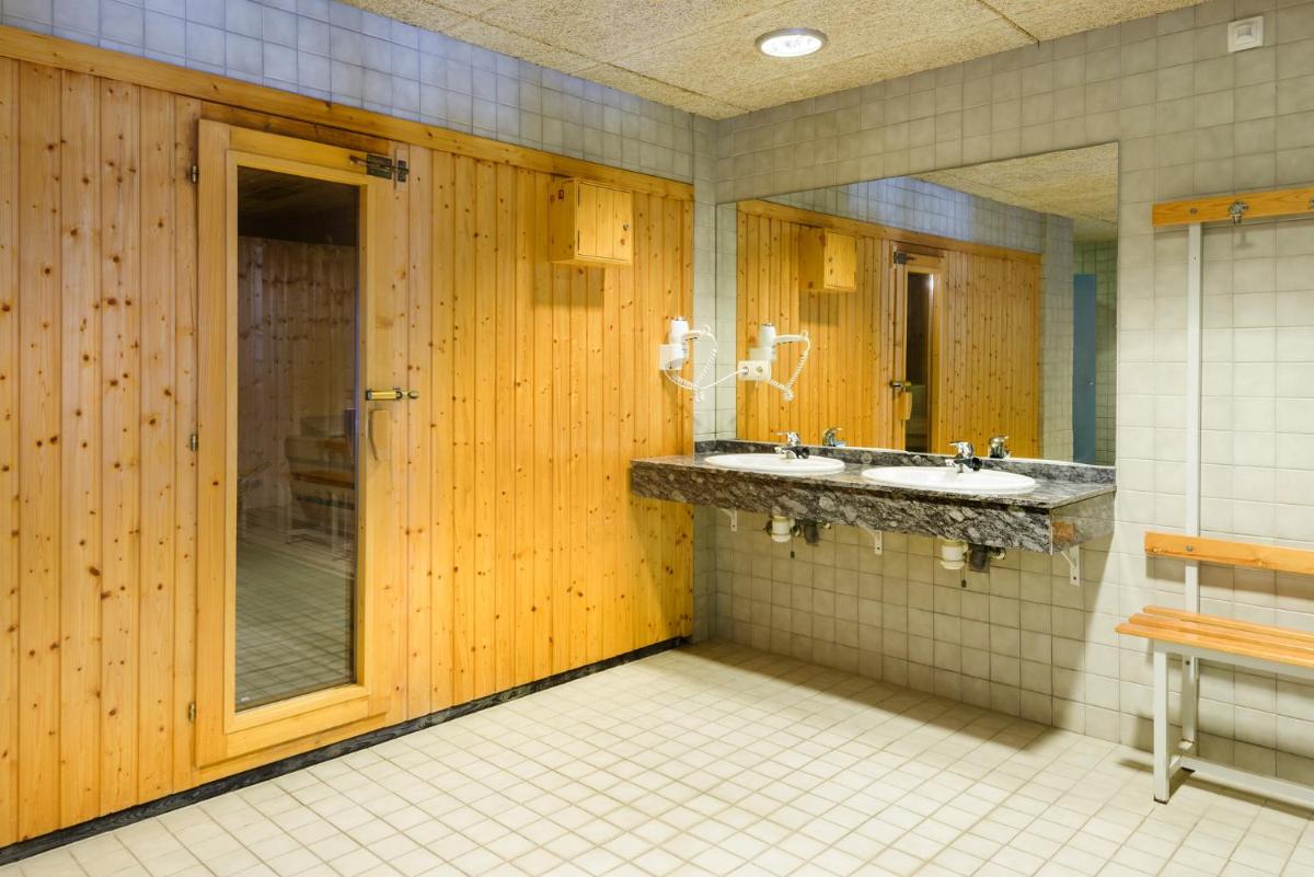 Un baño con dos lavabos y un espejo. en Hotel Saliecho, en Formigal