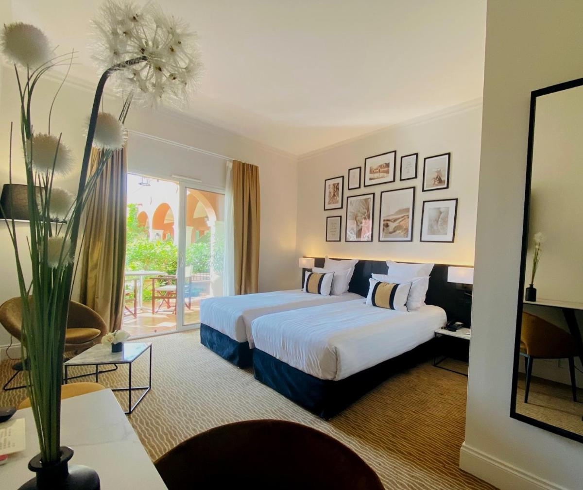 une chambre d'hôtel avec un lit et une fenêtre dans l'établissement Palmyra Golf Hotel & Spa, au Cap d'Agde