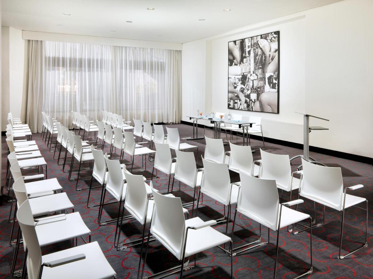 una sala de conferencias con sillas y mesas blancas en H10 Estepona Palace, en Estepona
