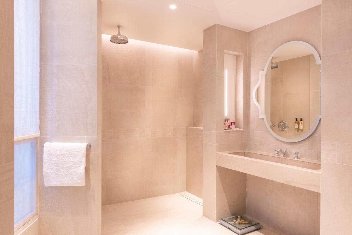 une salle de bain avec un lavabo et un miroir dans l'établissement Hotel de Montesquieu, à Paris 37 autres photos