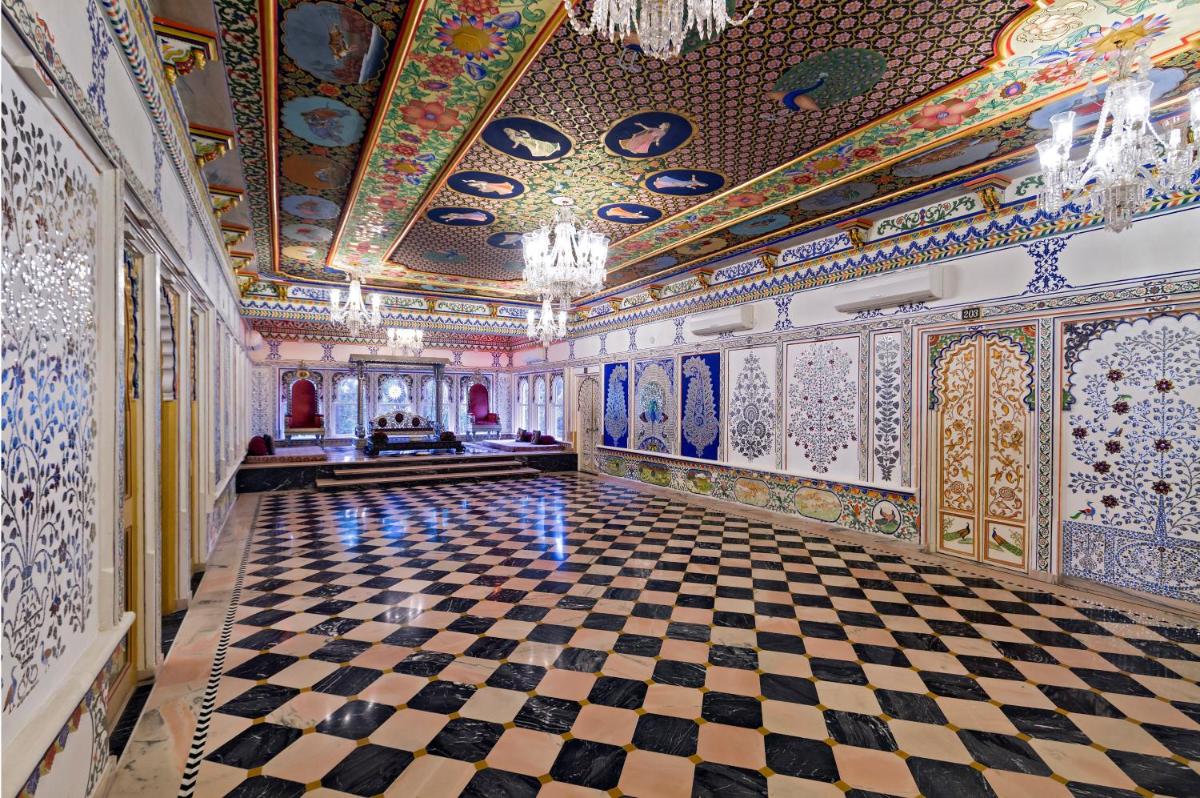 an ornate room with a checkerboard floor and a ceiling at Chunda Palace in Udaipur