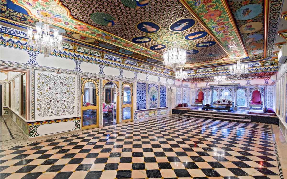 an ornate room with a checkered floor and a ceiling at Chunda Palace in Udaipur