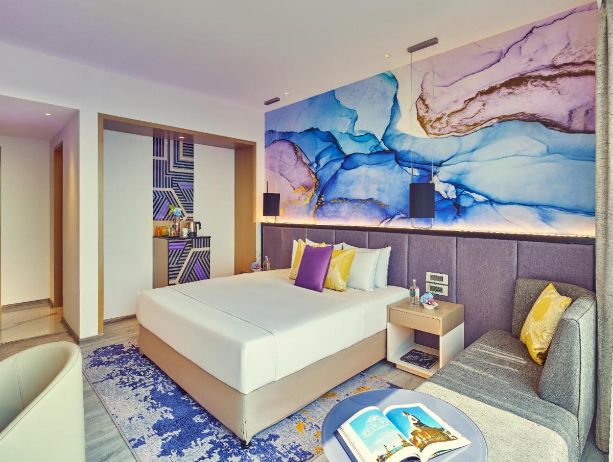 a bedroom with a bed and a couch at Vivanta Navi Mumbai Turbhe in Navi Mumbai