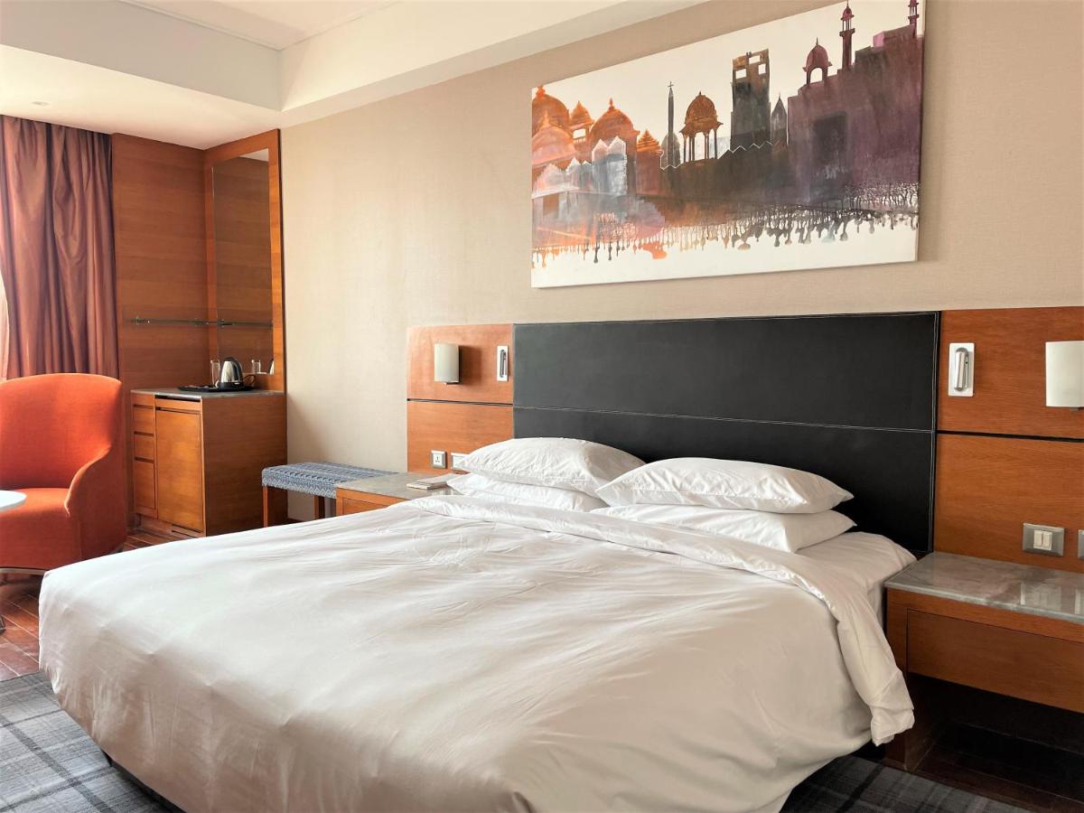a hotel room with a large bed and a chair at Hyatt Centric Janakpuri New Delhi in New Delhi
