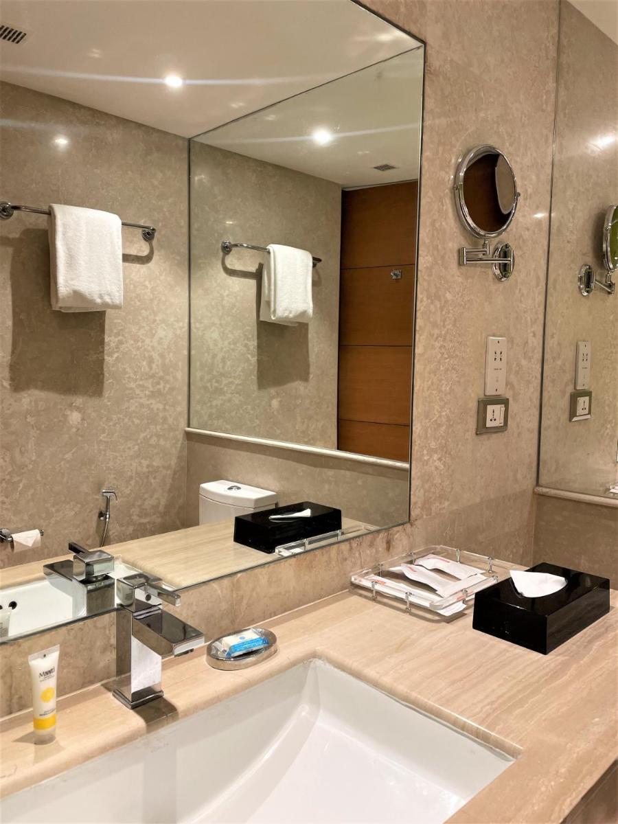 a bathroom with a sink and a large mirror at Hyatt Centric Janakpuri New Delhi in New Delhi