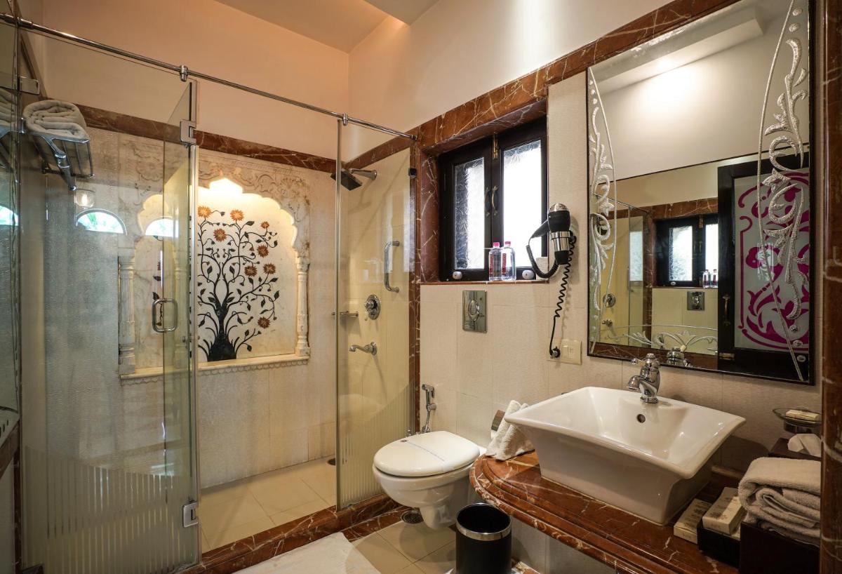 a bathroom with a toilet and a shower and a sink at Shahpura House in Jaipur
