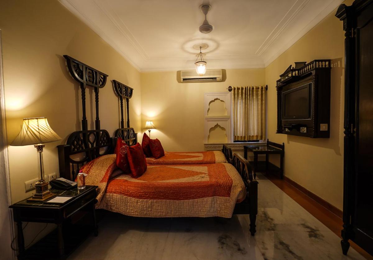 a bedroom with a bed and a television in it at Shahpura House in Jaipur