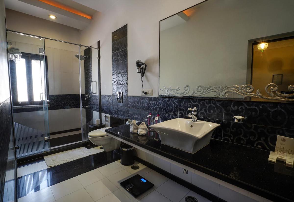 a bathroom with a sink and a shower and a toilet at Shahpura House in Jaipur