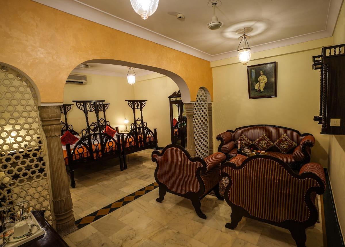a living room with chairs and tables in a room at Shahpura House in Jaipur