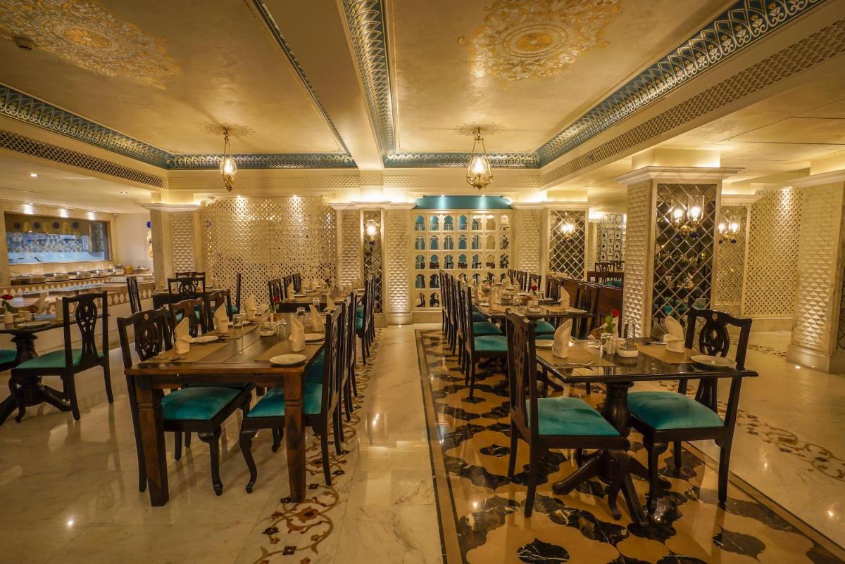 a restaurant with tables and chairs in a room at Shahpura House in Jaipur