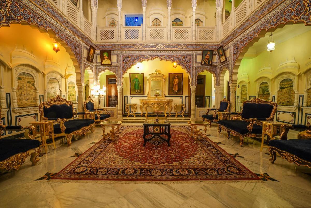 a large room with a rug in the middle of a building at Shahpura House in Jaipur