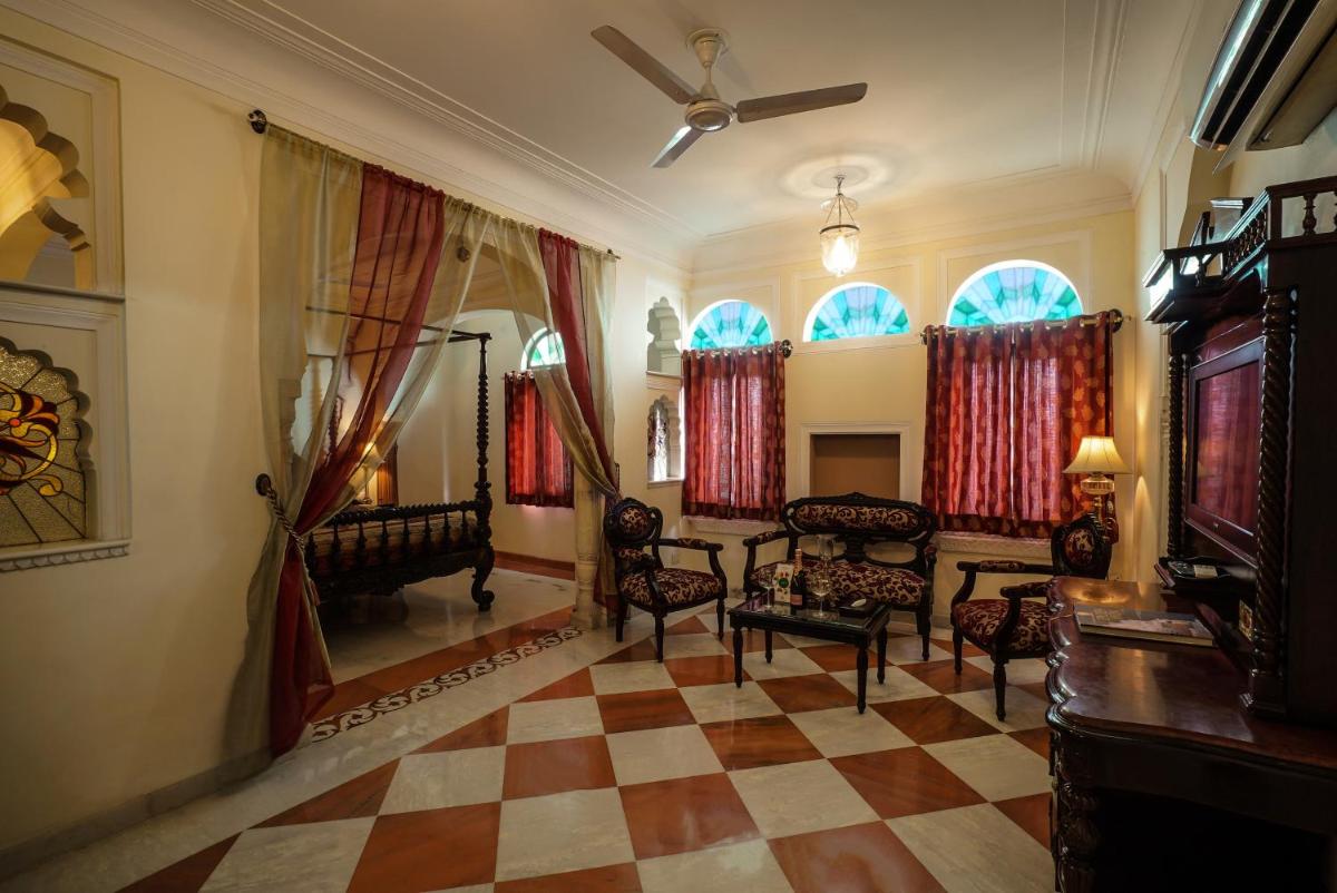 a living room with chairs and a checkerboard floor at Shahpura House in Jaipur