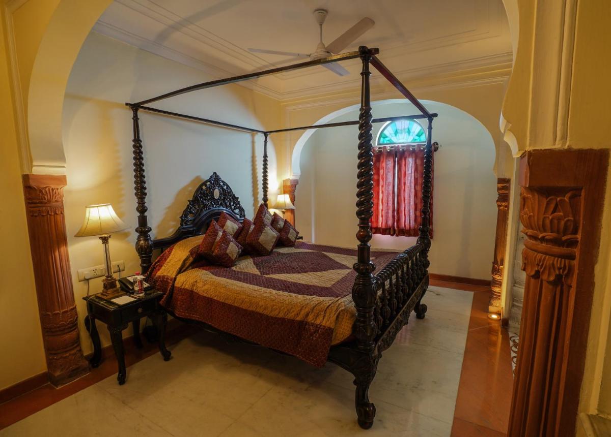 a bedroom with a canopy bed in a room at Shahpura House in Jaipur