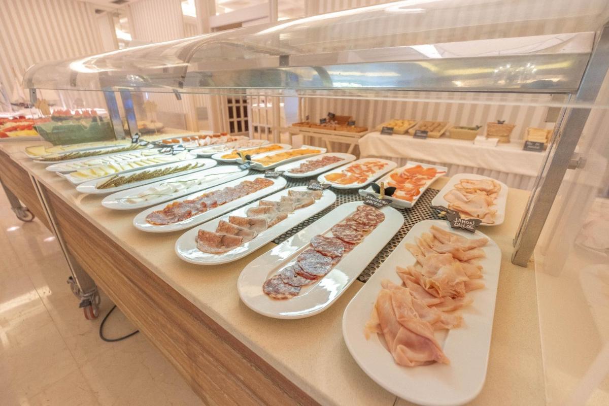 Una línea de buffet con muchos tipos diferentes de comida. en S'Agaró Hotel Spa & Wellness, en S'Agaró