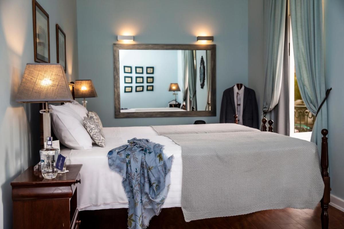 um quarto com uma cama branca e um espelho em Grande Hotel das Caldas da Felgueira nas Caldas da Felgueira mais 107 fotografias