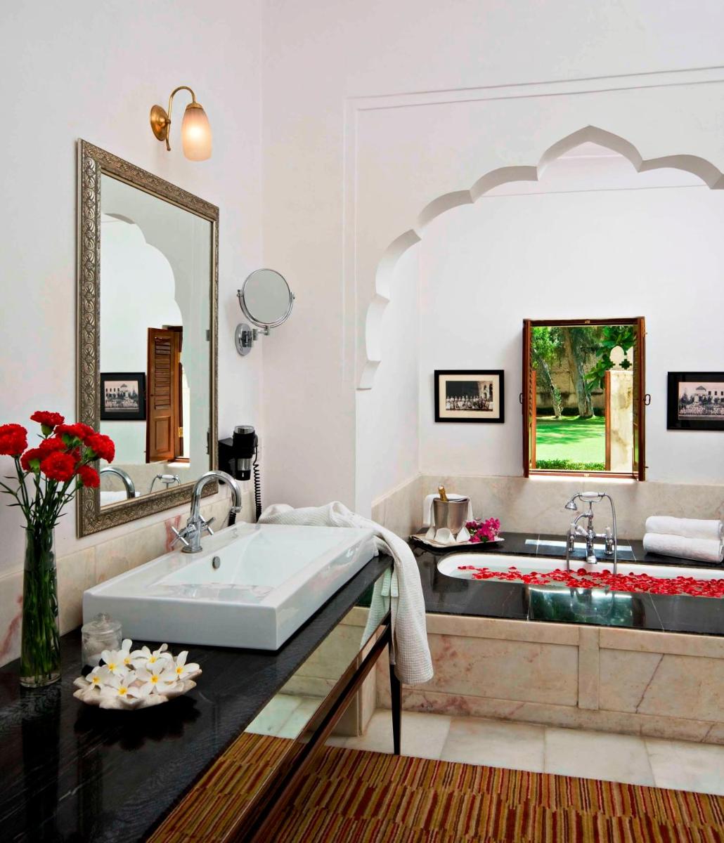 a bathroom with a large sink and a tub at Samode Haveli in Jaipur