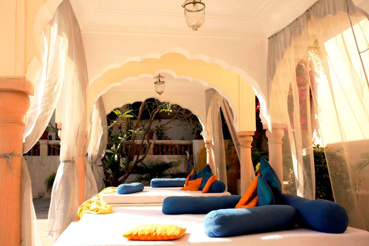 a group of four beds in a room at Samode Haveli in Jaipur