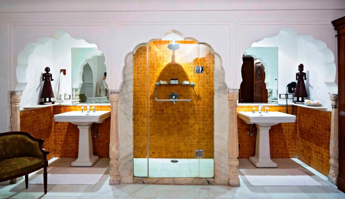 a bathroom with two sinks and a shower with two mirrors at Samode Haveli in Jaipur