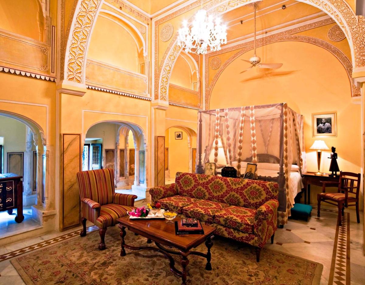 a living room with a couch and a table at Samode Haveli in Jaipur