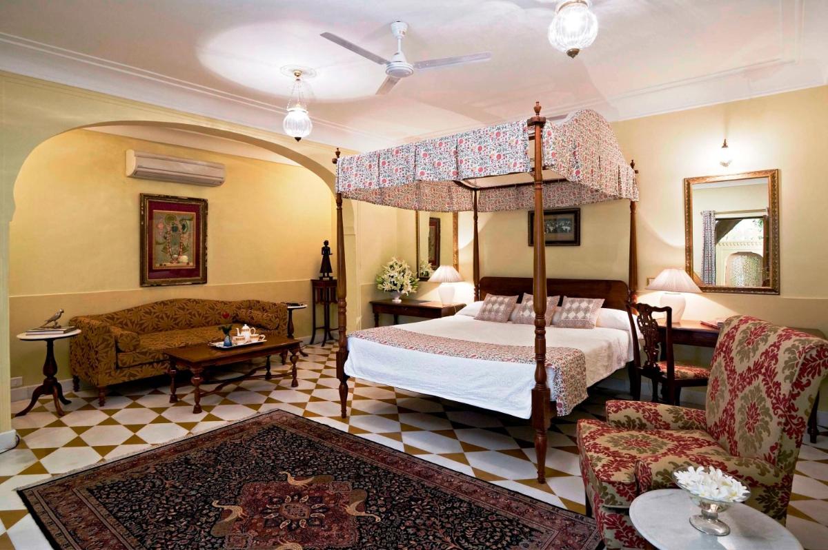 a bedroom with a canopy bed and a living room at Samode Haveli in Jaipur