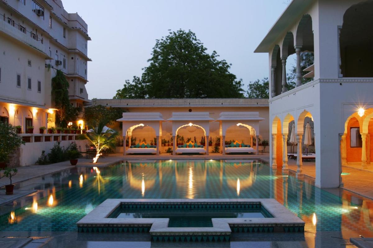 a courtyard with a swimming pool at night at Samode Haveli in Jaipur