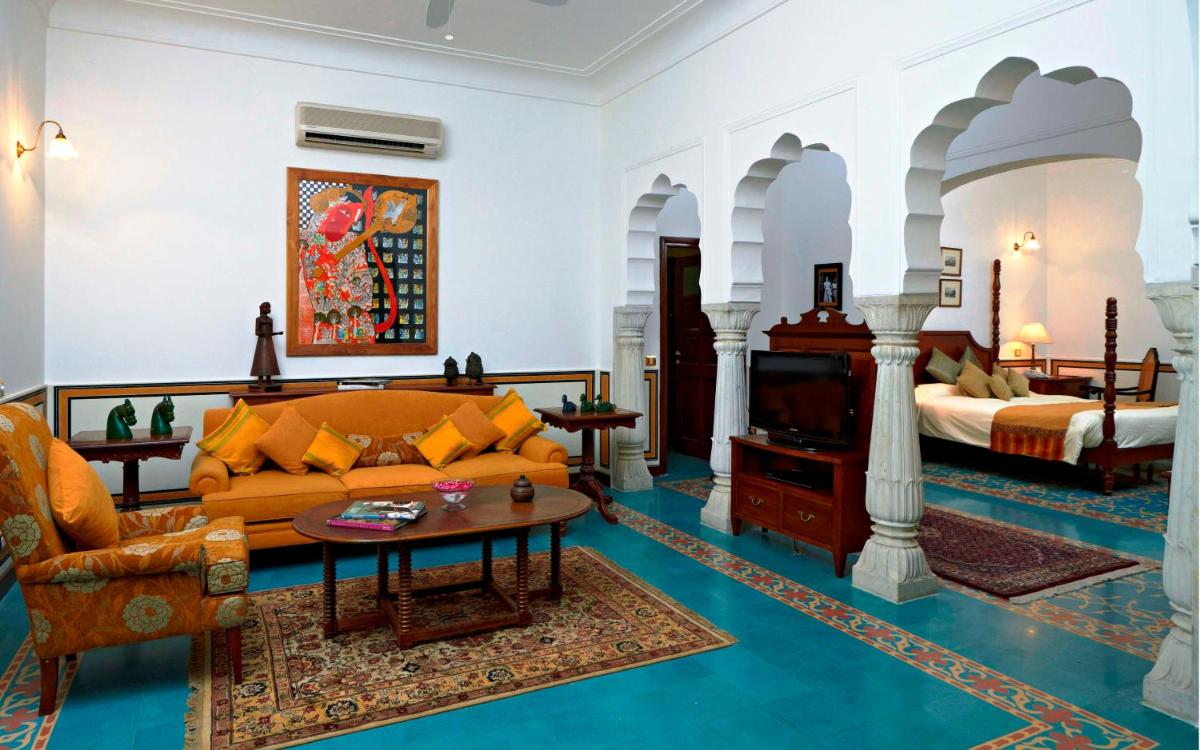 a living room with a couch and a bed at Samode Haveli in Jaipur