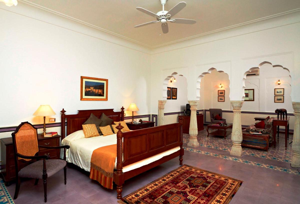 a bedroom with a bed and a living room at Samode Haveli in Jaipur