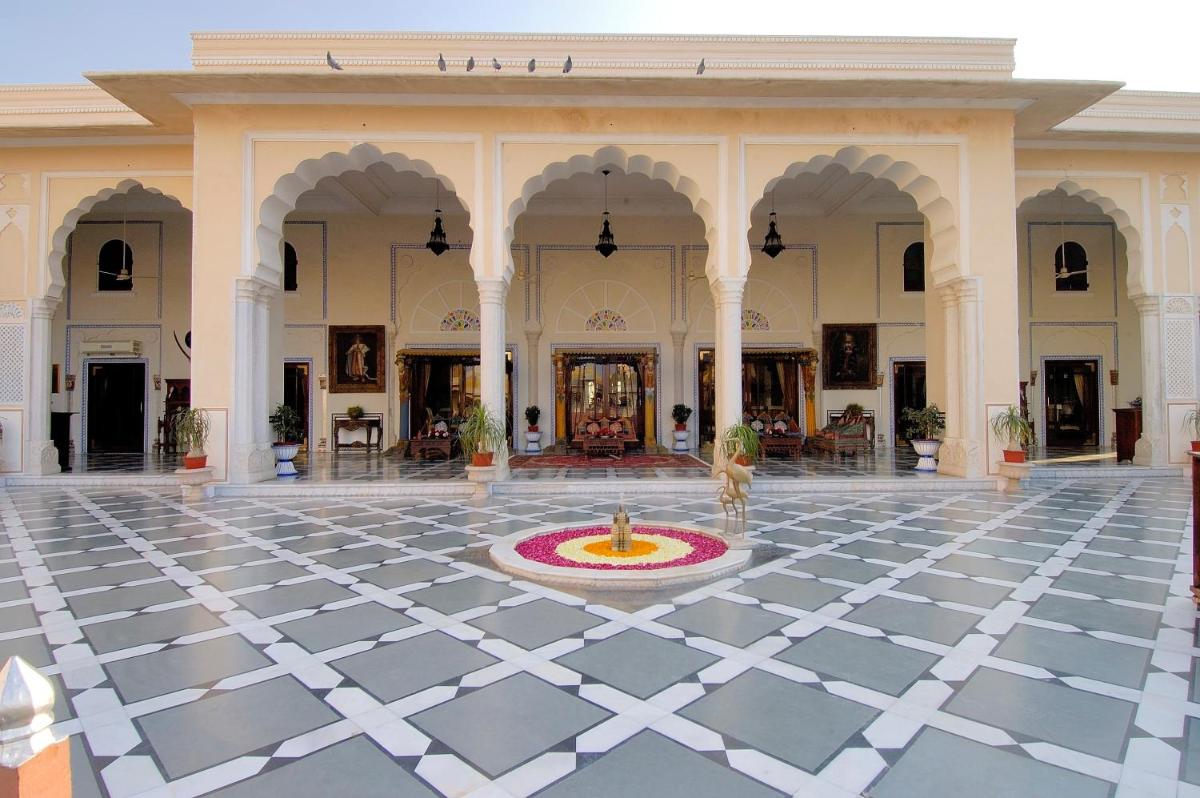 a courtyard with a fountain in the middle of a building at The Raj Palace (Small Luxury Hotels of the World) in Jaipur