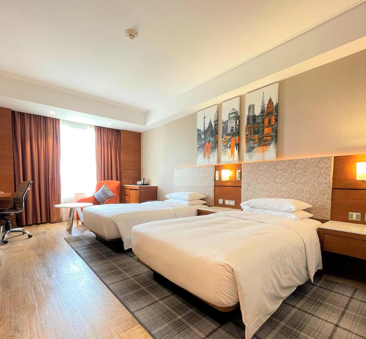 a hotel room with two beds and a desk at Hyatt Centric Janakpuri New Delhi in New Delhi