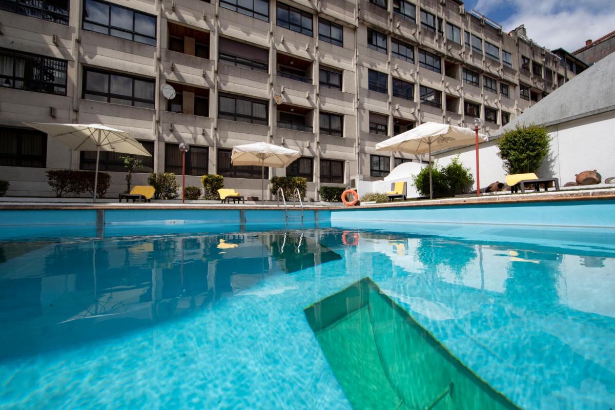 una piscina frente a un edificio en Eurostars Araguaney, en Santiago de Compostela