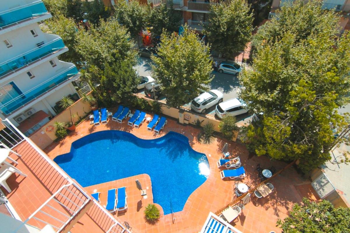 Una vista aérea de una piscina con sillas y árboles. en DWO Les Palmeres, en Calella