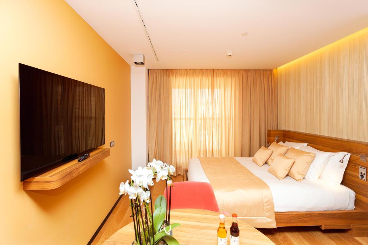 Una televisión o centro de entretenimiento en Bohemia Suites & Spa - Adults Only