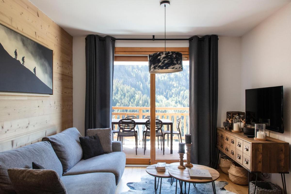 un salon avec un canapé et une table dans l'établissement TERRESENS - LES EDELWEISS, à Vaujany