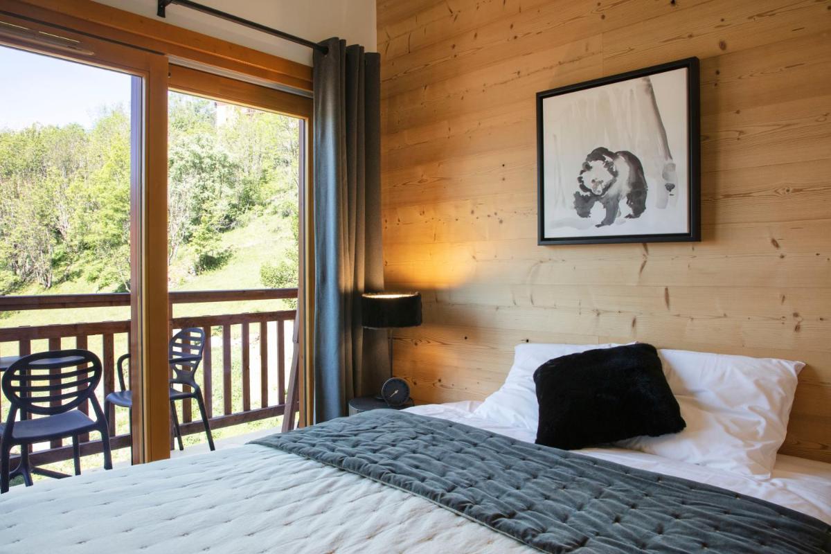 une chambre avec un lit et un balcon dans l'établissement TERRESENS - LES EDELWEISS, à Vaujany
