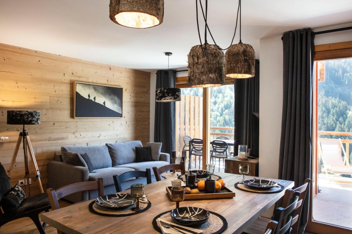 un salon avec une table et un canapé dans l'établissement TERRESENS - LES EDELWEISS, à Vaujany