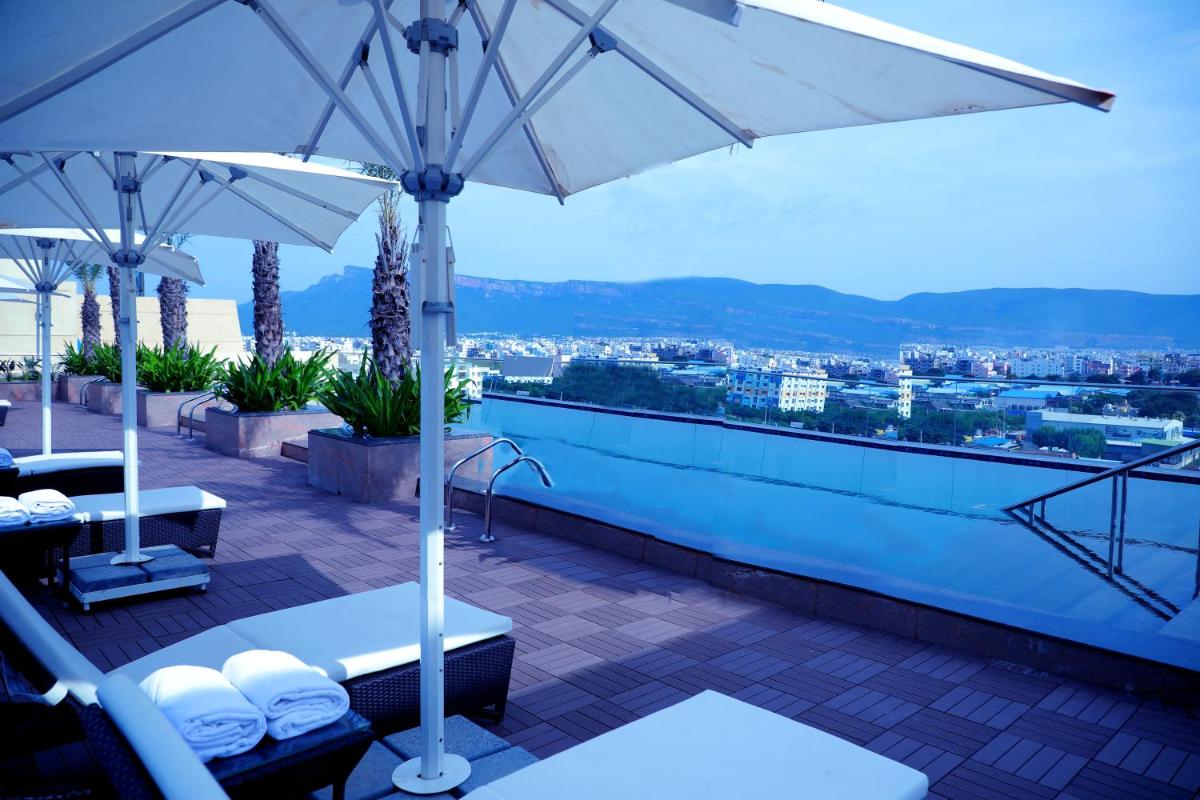 a rooftop patio with umbrellas and a view at Taj Tirupati in Tirupati