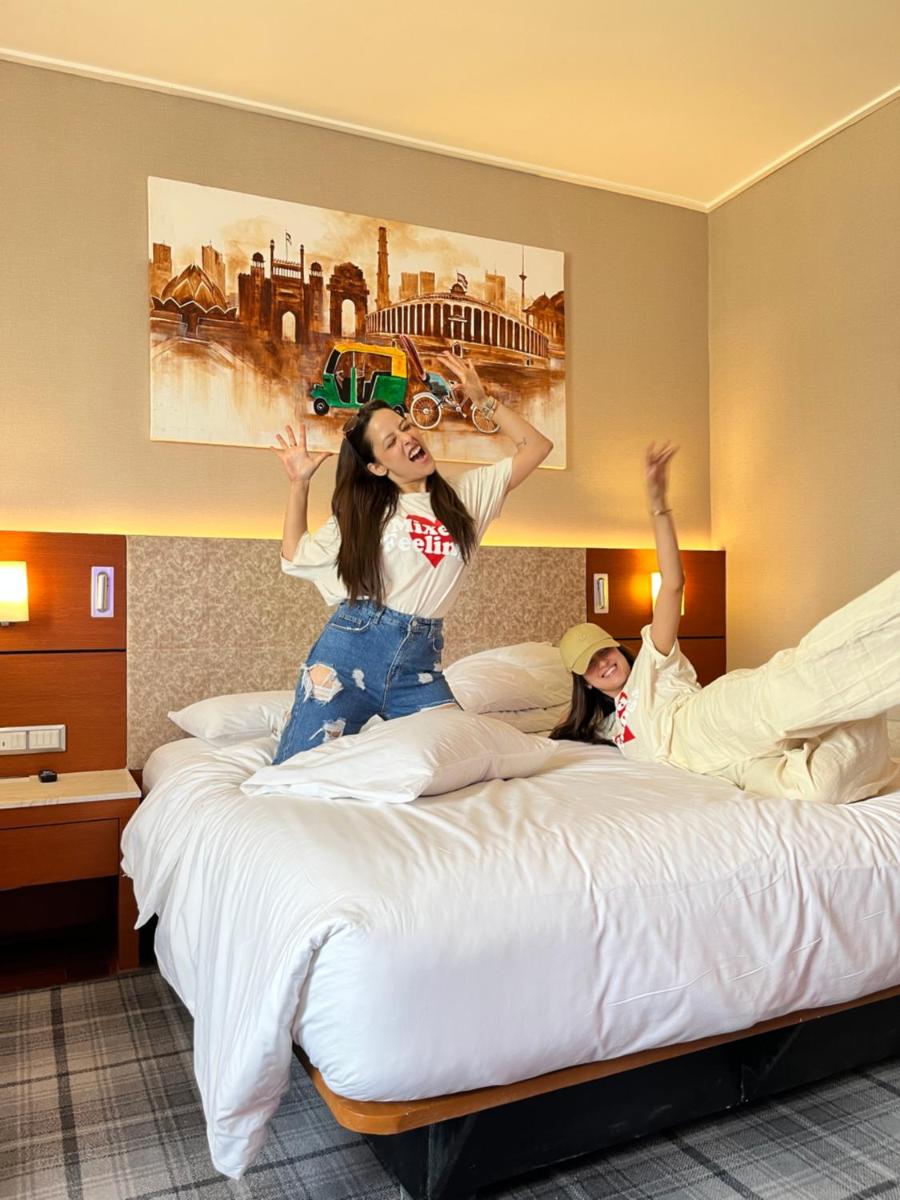 two girls jumping on beds in a hotel room at Hyatt Centric Janakpuri New Delhi in New Delhi