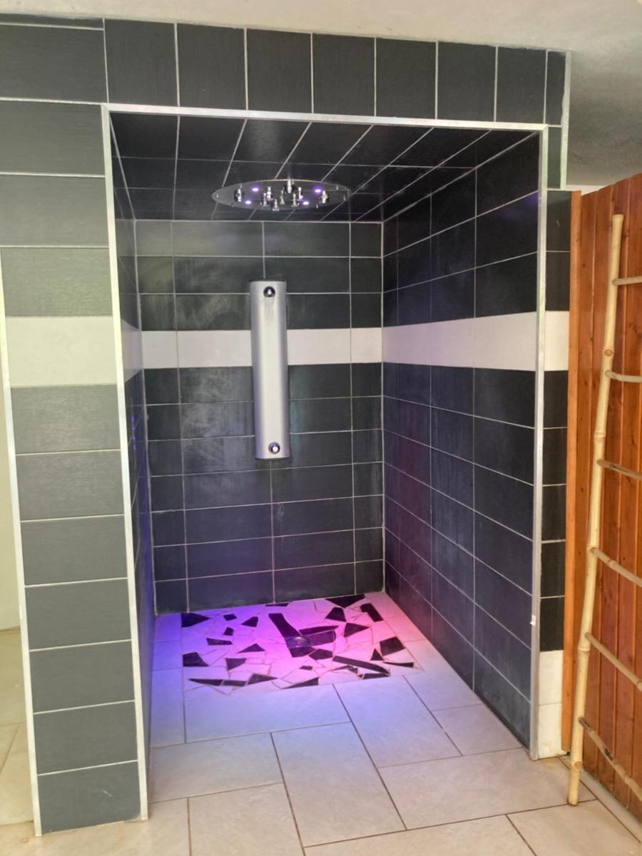 une salle de bain avec douche aux carreaux violets dans l'établissement Hôtel Spa L'Ermitage, aux Salles-sur-Verdon