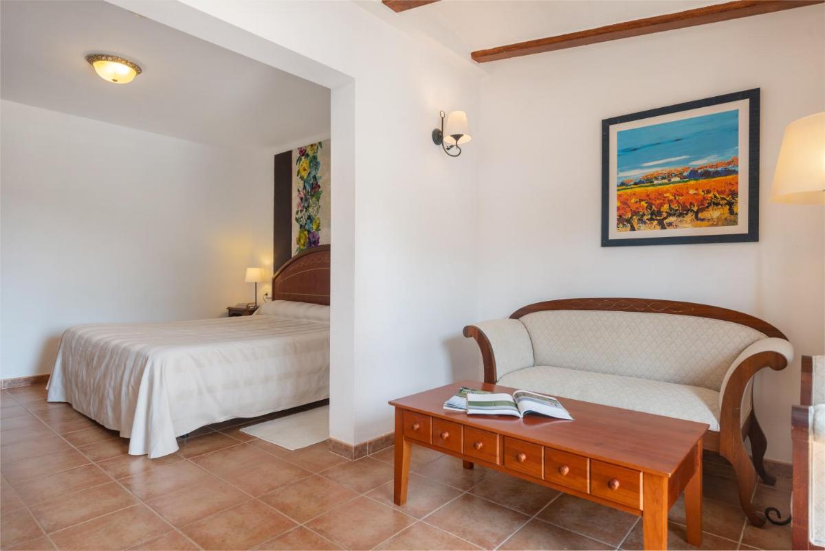 Un dormitorio con una cama, un sofá y una mesa. en Monnaber Nou Finca Hotel & Spa, en Campanet 125 fotos más