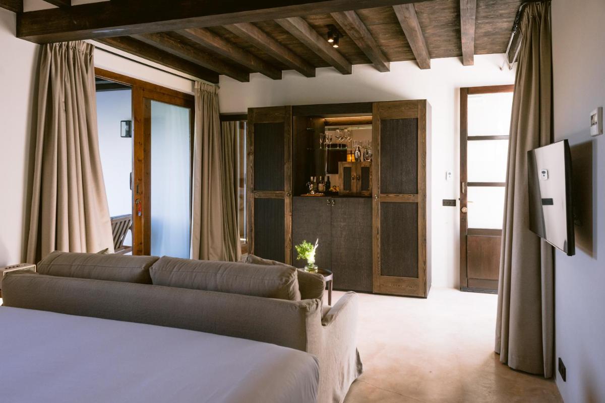 Un dormitorio con una cama y un sofá en una habitación. en Casa Maca, en Ibiza
