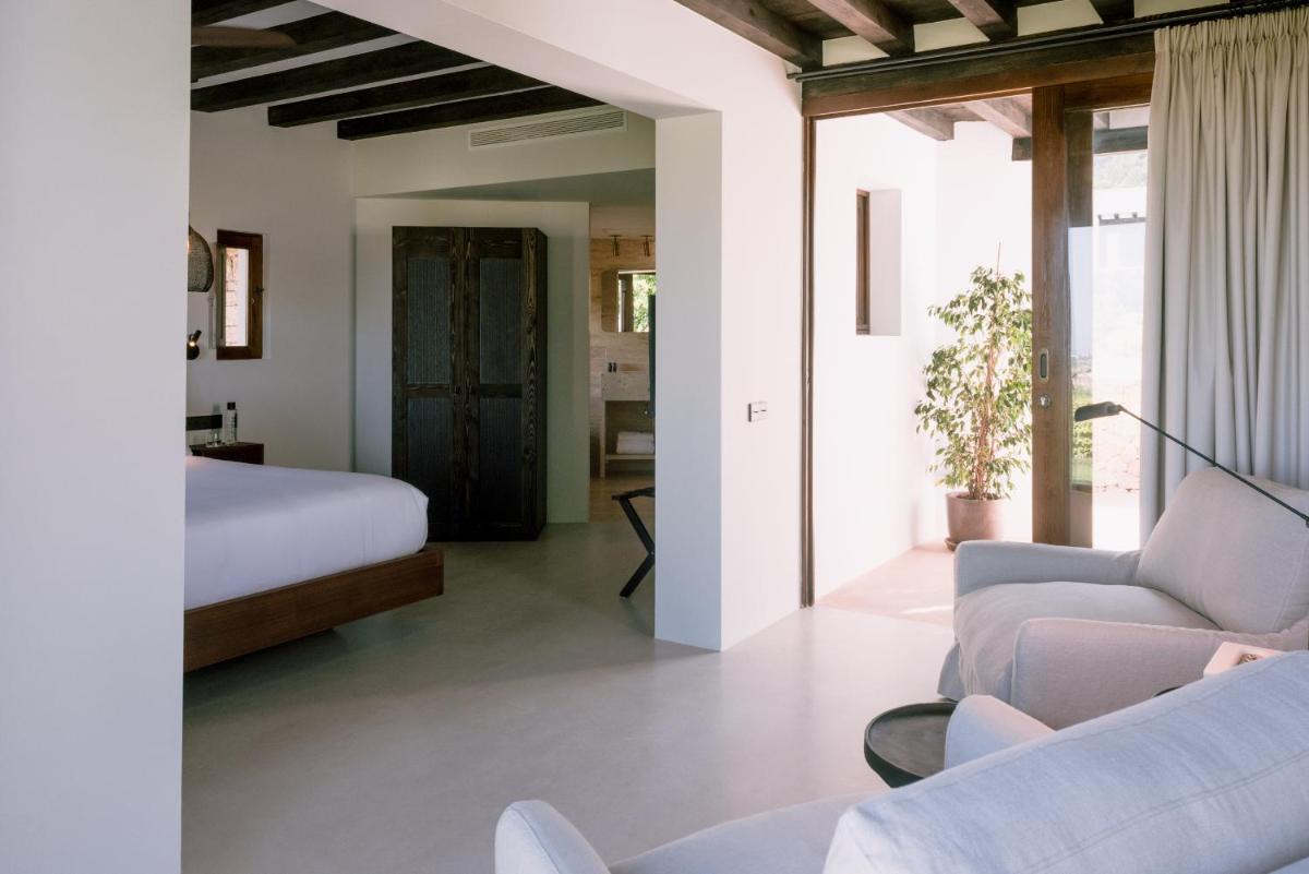 Un dormitorio con una cama y una sala de estar con un sofá. en Casa Maca, en Ibiza