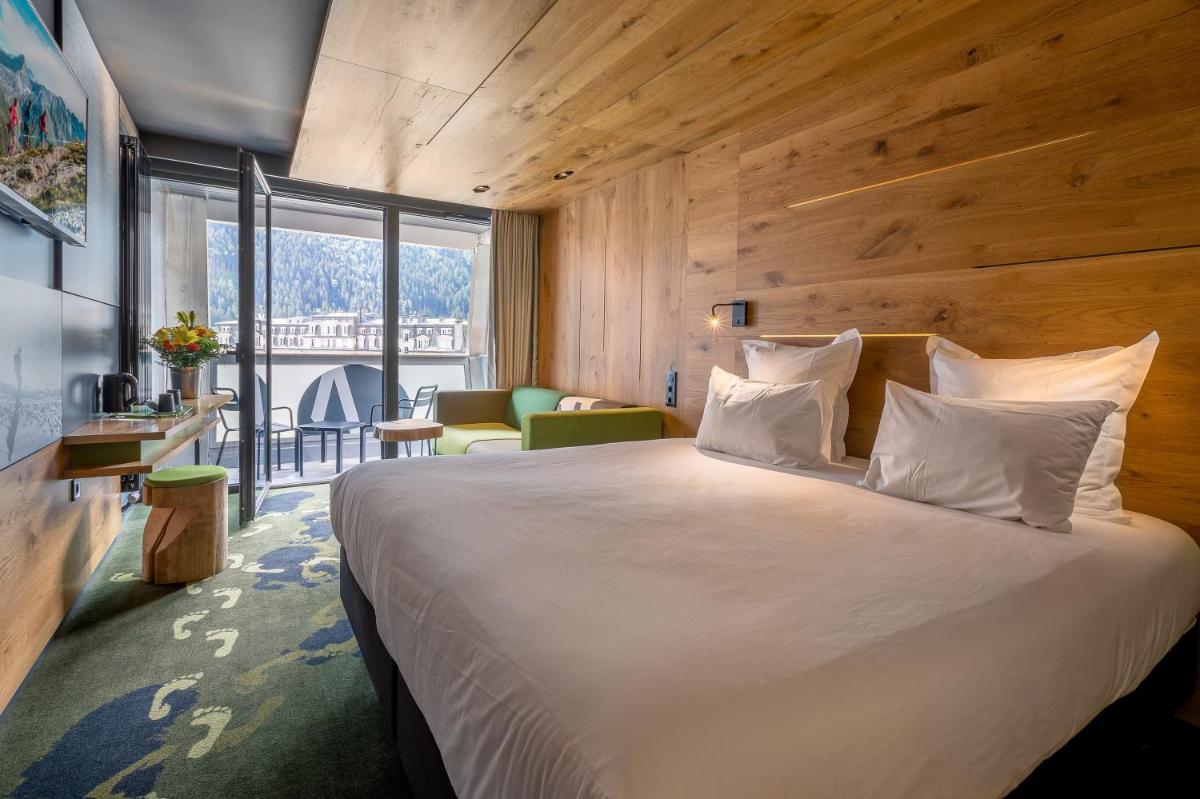une chambre avec un grand lit et une grande fenêtre dans l'établissement Alpina Eclectic Hotel, à Chamonix-Mont-Blanc 75 autres photos