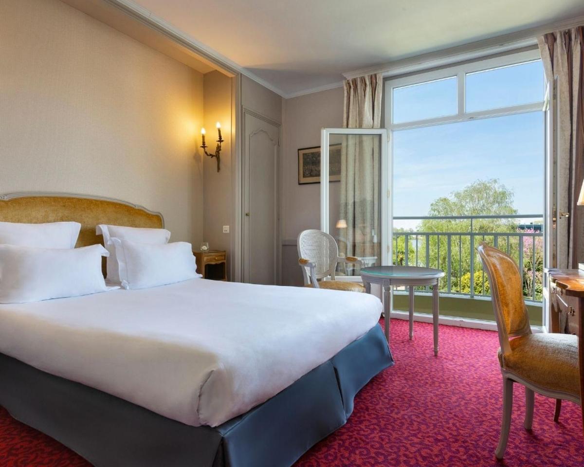 une chambre d'hôtel avec un grand lit et une fenêtre dans l'établissement Hôtel Barrière le Grand Hôtel Enghien-les-Bains, à Enghien-les-Bains
