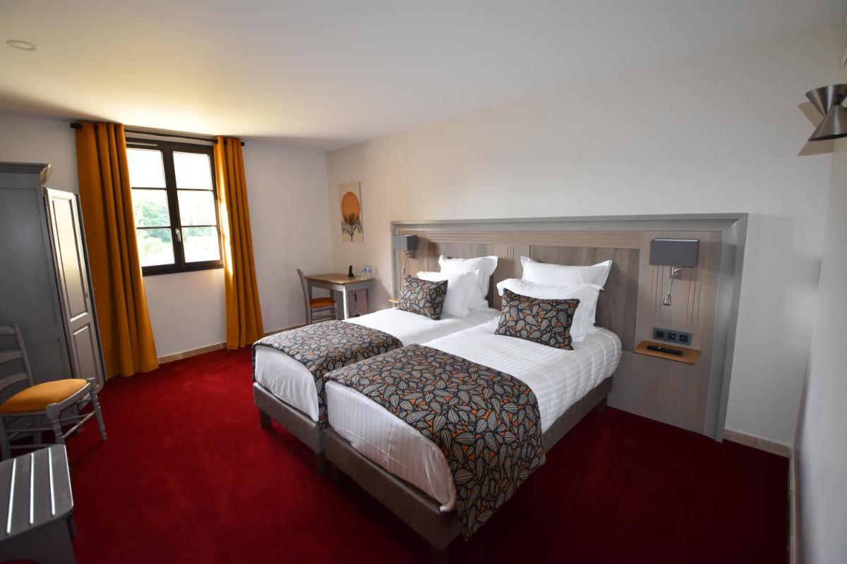 Un ou plusieurs lits dans un hébergement de l'établissement Hotel Le Perigord