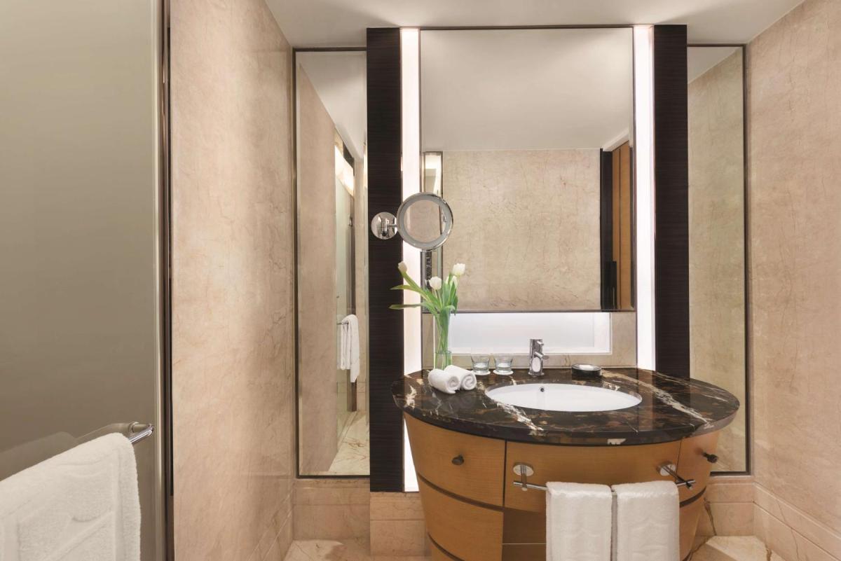 a bathroom with a sink and a mirror at Shangri-La Bengaluru in Bengaluru a bathroom with a sink and a mirror at Shangri-La Bengaluru in Bengaluru
